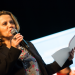 Frédérique Penilla, directrice du CLA, tenant un micro et des feuilles de papier