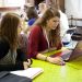 Une salle où des étudiants travaillent. Deux filles au premier plan.