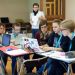 Un groupe d'étudiants au travail. Quelqu'un en retrait les observe.