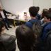 Un enseignant montre un dispositif expérimental devant un groupe de lycéens.