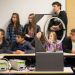 Un dispositif expérimental avec un cercle équipé de leds, en arrière plan un groupe de lycéens.