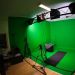 Une salle recouverte d'un fonds vert avec des éclairages de cinéma.