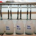 Des vis suspendues au-dessus de petits flacons